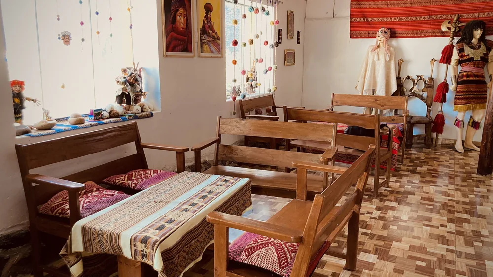 Comedor del hospedaje con mesas de madera y artesanías locales